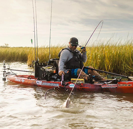 angler with a fish on the line in the flats in a yupik jackson kayak